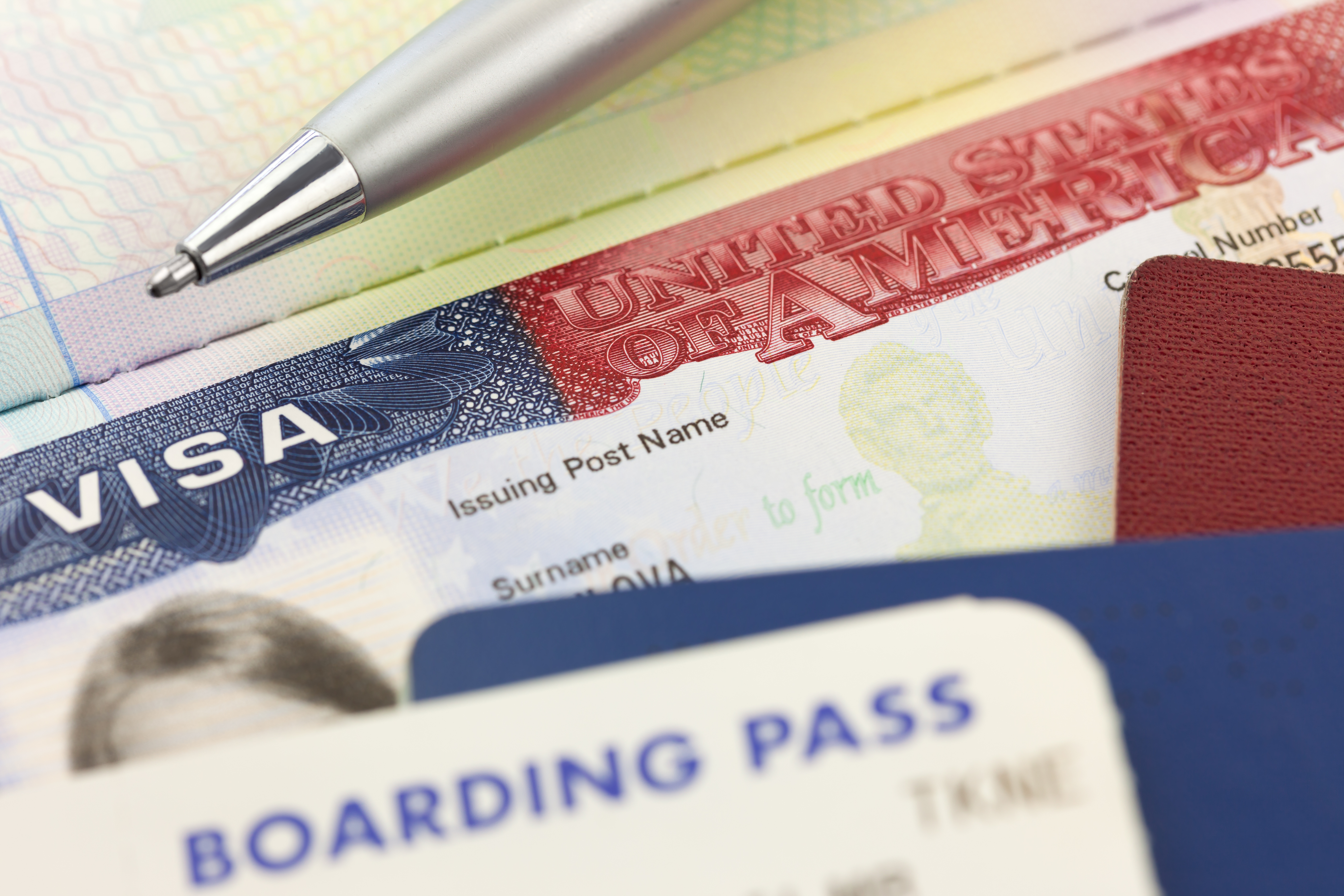 USA Visa, passports, boarding pass and pen - foreign travel background