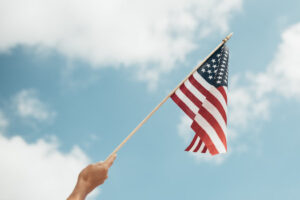 A woman waving a US flag toward the sky