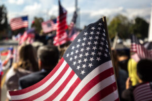 A crowd of people waving US flags