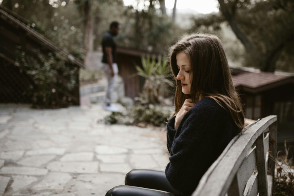 woman sitting on a bench looking sad