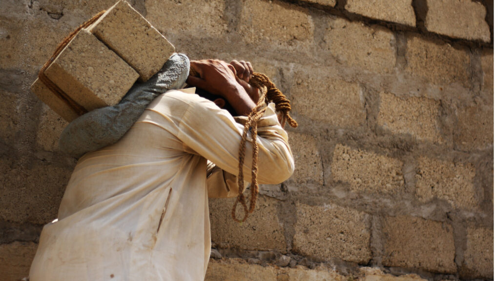 man carries bricks on his back