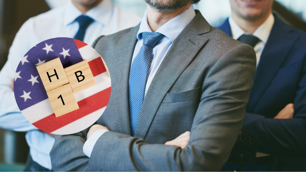 a man in suit hloding an american flag with a que board logo hb1